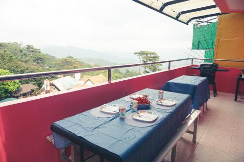a table with plates of food on a balcony at Cozy Baguio House - Outlook Drive (DOT accredited) in Baguio