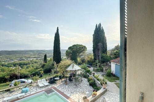 Blick auf eine Villa mit Pool und Bäumen in der Unterkunft Charming Provencal studio with a large swimming pool and a view of the hill in Montauroux