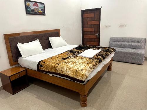 PARI HOMESTAY في خاجوراهو: غرفة نوم بسرير وكرسي وأريكة
