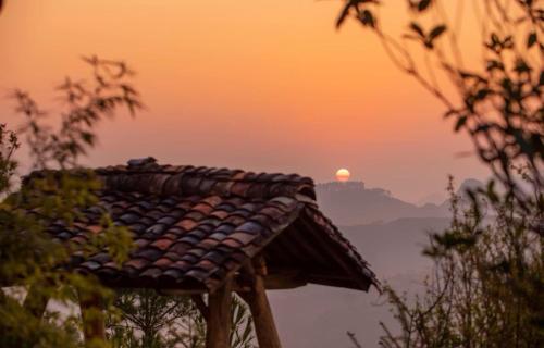 a roof of a house with the sunset in the background at Khói Panorama in Dồng Văn