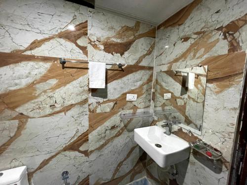 baño con lavabo y pared de mármol en PARI HOMESTAY en Khajurāho