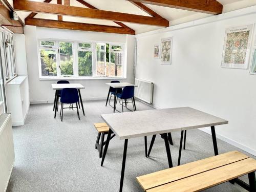 una habitación con mesas, sillas y ventanas en City Centre Guest House, en Gloucester