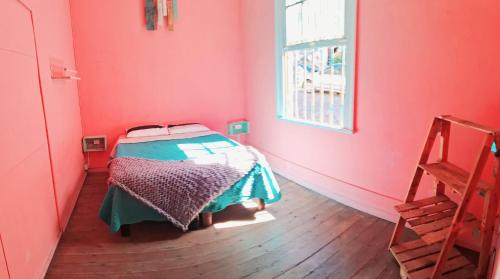 een slaapkamer met een bed in een rode kamer bij Valpro Hostal in Valparaíso