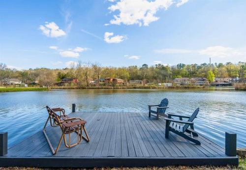a dock with two chairs and a bench on a lake at The Bungalow in Hot Springs