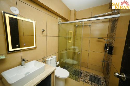 a bathroom with a toilet and a sink and a shower at Saikiran Hotel in Mapusa