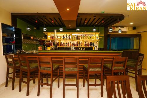 un bar con sillas de madera y barra de bar en Saikiran Hotel, en Mapusa