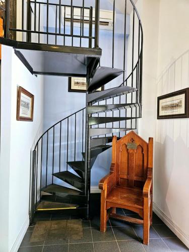 a spiral staircase with a wooden chair next to a stair case at The Camperdown Mill in Camperdown
