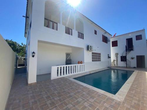 a house with a swimming pool next to a building at Casa Zanelli, lugar de paz… in Baní