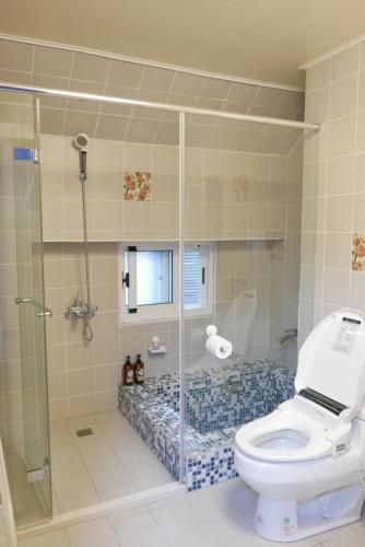 La salle de bains est pourvue de toilettes et d'une douche en verre. dans l'établissement Café des Mémoires 兩條內褲南法鄉村民宿, à Puli
