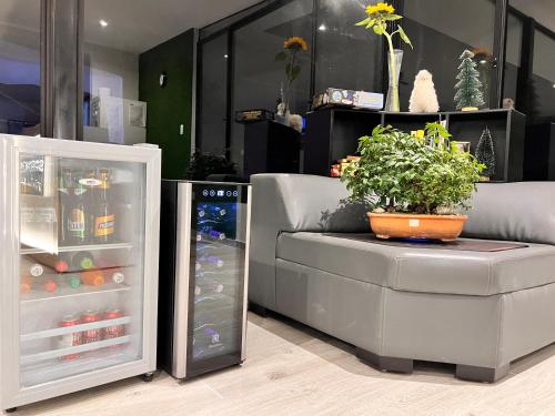 a couch with a plant on it next to a refrigerator at Springhills Quito Airport in Tababela