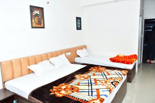 - 2 lits dans une chambre d'hôtel avec couverture dans l'établissement DESIRE LODGE, à Dālkola