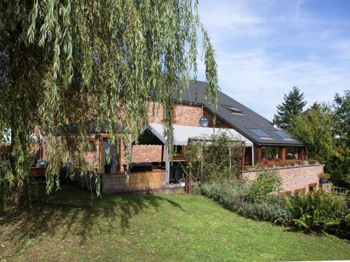 a brick house with a greenhouse in the yard at Atmospheric holiday home in Durbuy with sauna in Septon