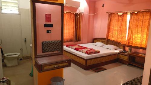 a small bedroom with a bed and a mirror at Hotel Sunny New Digha Near Sea Beach View Point - Couple Friendly in Digha