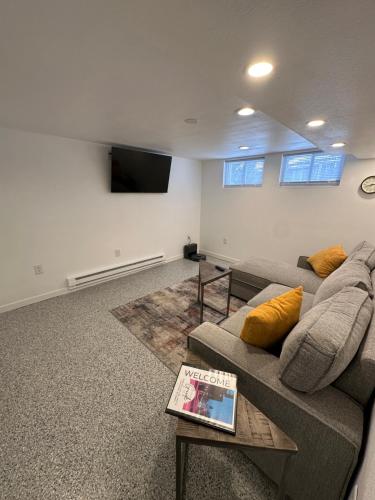 a living room with a couch and a tv at Basement Bliss: Cozy Getaway in Cheyenne