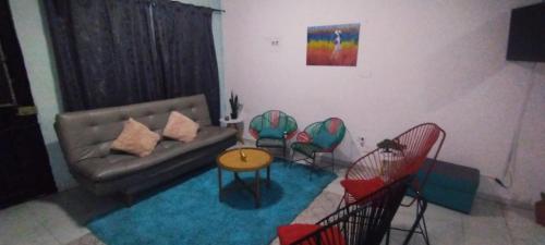 ein Wohnzimmer mit einem Sofa und Stühlen in der Unterkunft Casa Holandesa con piscina privada in Mariquita