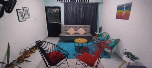ein Wohnzimmer mit einem Sofa, einem Tisch und Stühlen in der Unterkunft Casa Holandesa con piscina privada in Mariquita