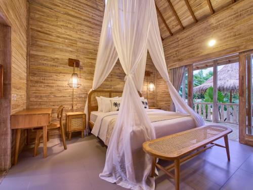 a bedroom with a bed and a table and a desk at Uluwatu Desa in Uluwatu