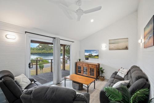 a living room with two couches and a table at The Stag Cabin 4 in Mylestom