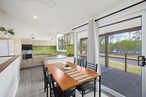 a kitchen and dining room with a table and chairs at The Stag Cabin 4 in Mylestom