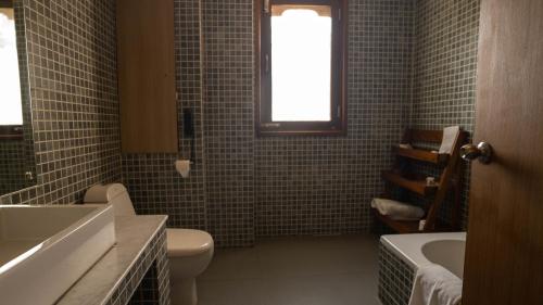 a bathroom with a toilet and a sink and a tub at Hotel Osel in Thimphu
