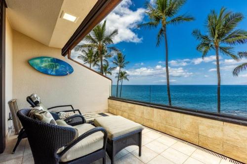 a balcony with a view of the ocean and palm trees at MAKENA SURF, #E-303 condo in Wailea