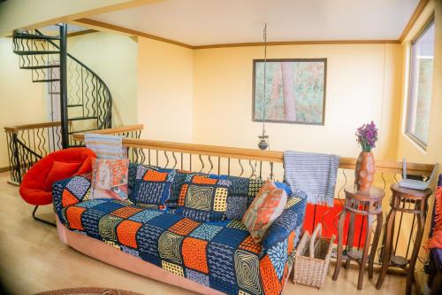 a living room with a couch and a staircase at Cozy Baguio House - Outlook Drive (DOT accredited) in Baguio