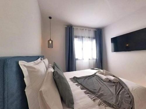 a bedroom with a bed with a blue couch and a window at Yellow Apartment in Puerto del Rosario in Puerto del Rosario