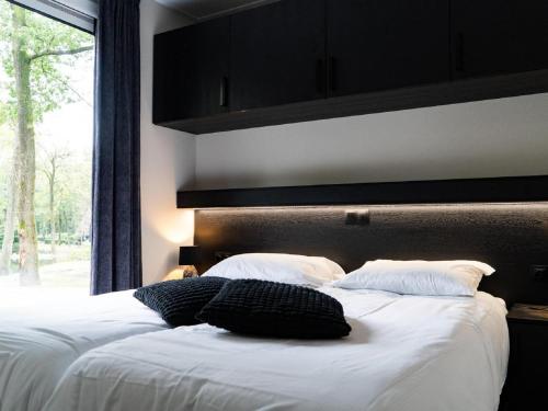 1 dormitorio con 2 camas y ventana grande en Modern holiday home with decorative fireplace near Veluwe en Hoenderloo