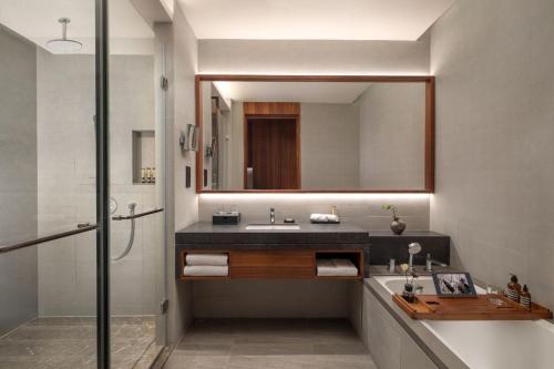 W łazience znajduje się umywalka i lustro. w obiekcie Oakwood Suites Chongli w mieście Chongli