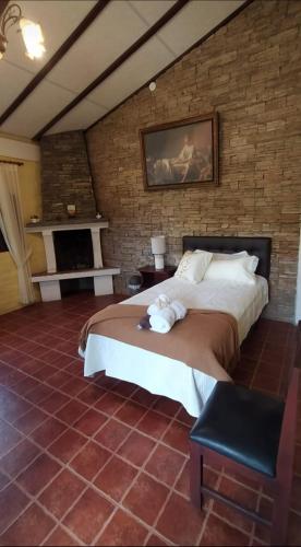 een slaapkamer met een groot bed in een bakstenen muur bij Quinta Sierra de Fuego in Penipe