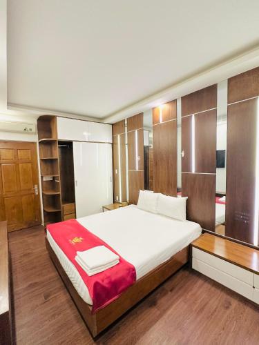 a bedroom with a large white bed and wooden cabinets at Lộc Thiên Ân hotel in Bien Hoa
