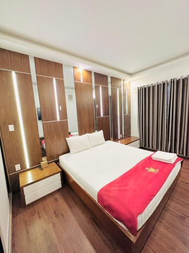 a bedroom with a large bed with a red blanket at Lộc Thiên Ân hotel in Bien Hoa