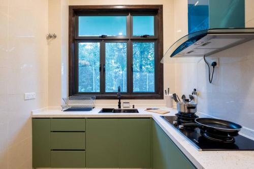 a kitchen with a sink and a stove and a window at Bungalow Putrajaya 15pax w Private Pool Gathering in Putrajaya
