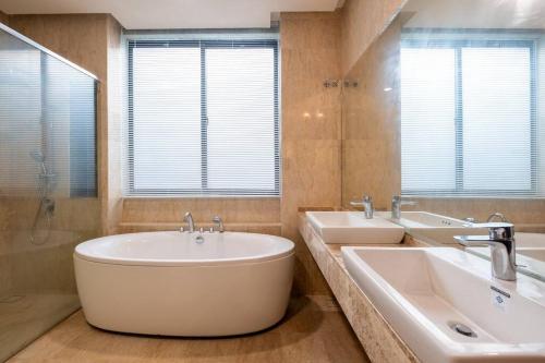 a bathroom with two sinks and a tub at Bungalow Putrajaya 15pax w Private Pool Gathering in Putrajaya