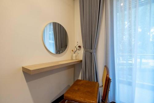 a room with a mirror and a table and a window at Bungalow Putrajaya 15pax w Private Pool Gathering in Putrajaya