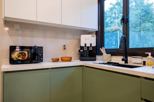 a kitchen with a counter top with a microwave at Bungalow Putrajaya 15pax w Private Pool Gathering in Putrajaya