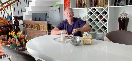 a man sitting at a table with a plate of food at The Dragon Villa Hoi An in Hoi An