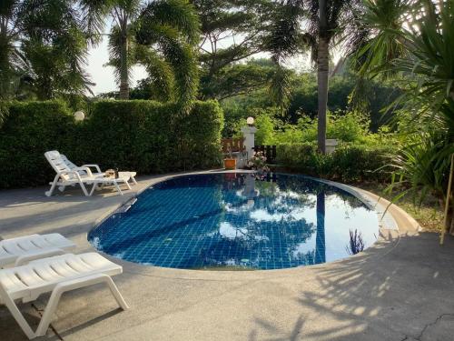 een klein zwembad met een stoel en een tafel bij แกรนด์ฮิลล์ เฮาส์ Grandhill house in Hua Hin