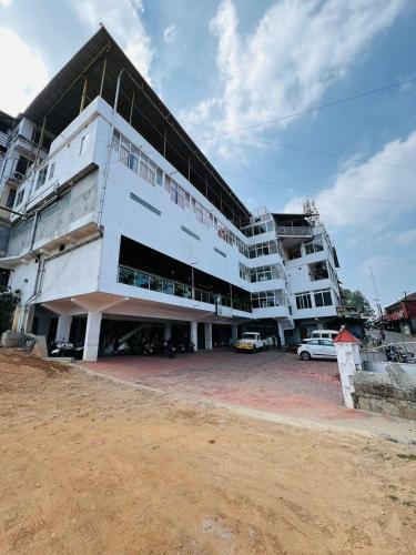 a large white building with cars parked in front of it at HOTEL CHRUCH SIDE in Madikeri