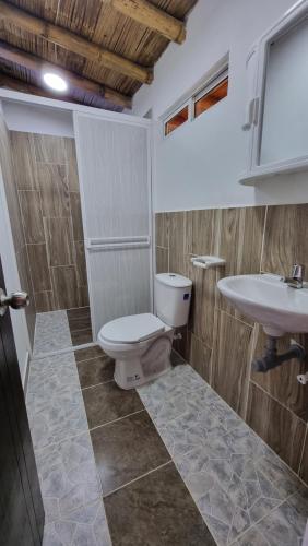 a bathroom with a toilet and a sink at Cabaña del lago in Cocorná