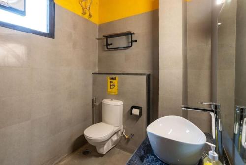 La salle de bains est pourvue de toilettes blanches et d'un lavabo. dans l'établissement Corbett Wild Resorts & Spa, à Garjia