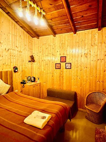 a bedroom with a bed in a room with wooden walls at Aqua De Vida in Bhowāli
