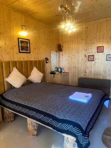 a bedroom with a bed in a wooden room at Aqua De Vida in Bhowāli