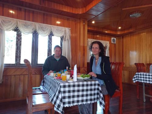 a man and a woman sitting at a table at Sipanya Guesthouse in Muang Phônsavan