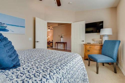 a bedroom with a bed and a chair and a television at HavaCabana Pool Spa Games Lake View Garage in Lake Havasu City