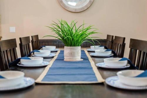 a table with plates and bowls and a plant on it at HavaCabana Pool Spa Games Lake View Garage in Lake Havasu City