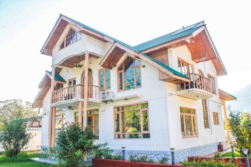 een huis met witte muren en ramen bij Burj Cottage , Pahalgam in Pahalgām