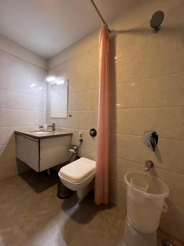 a bathroom with a toilet and a sink and a tub at Hotel Shri Radha Nikunj - Opposite Prem Mandir in Vrindāvan