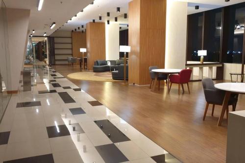 a lobby with tables and chairs in a building at The Modern Stay Supermall U-Residence-3 with City View in Klapadua