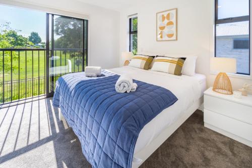 a bedroom with a bed and a large window at Escape at the park: 1 bed 1 bath w/carpark in Christchurch